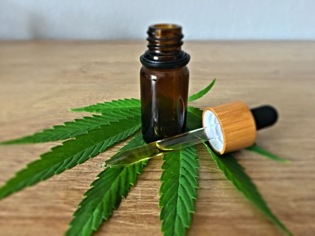 cbd oil dropper and cannabis leaf
